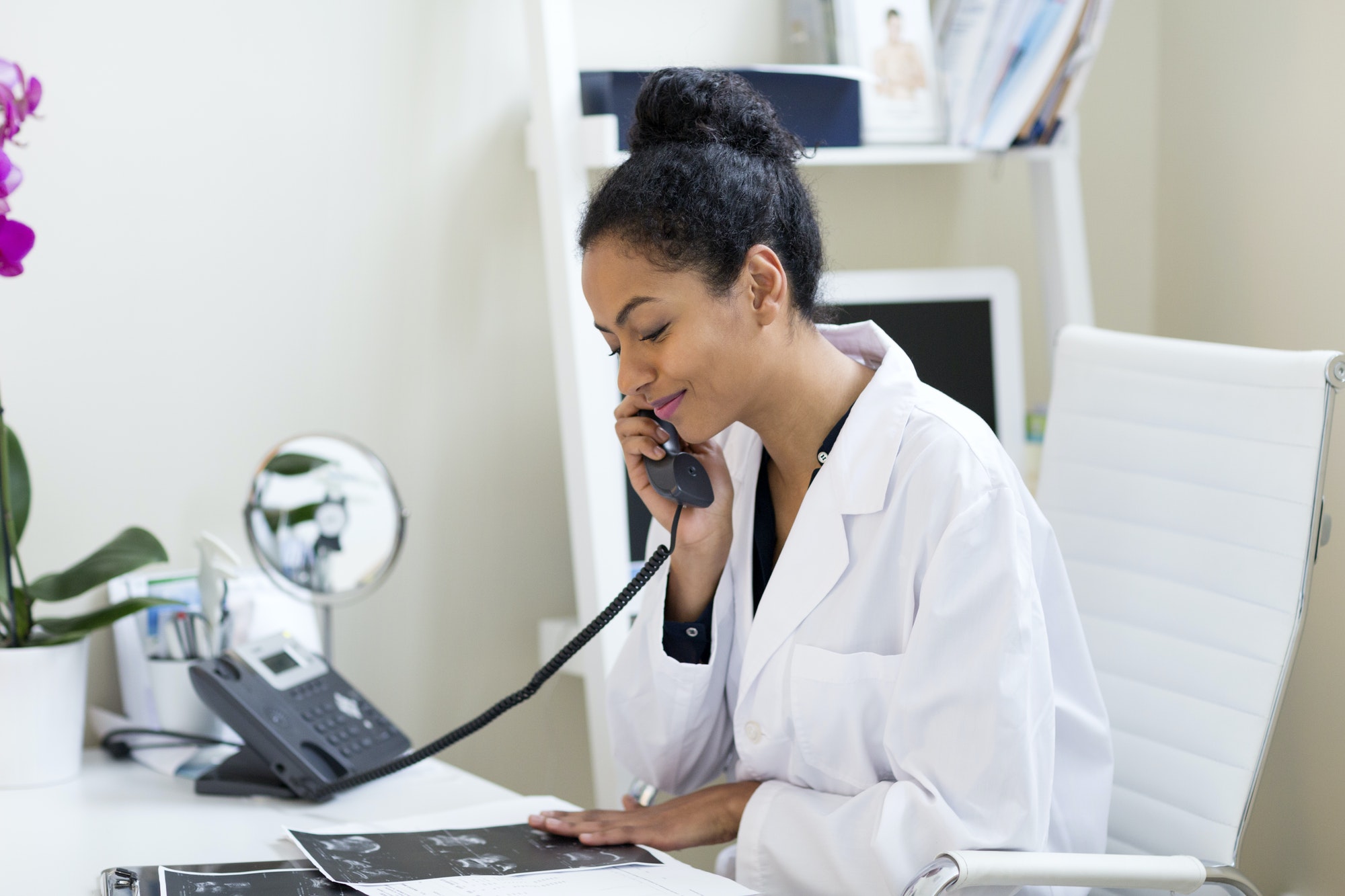 Doctor at desk making telephone call