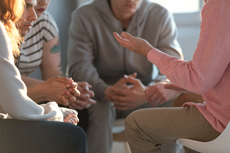 People share their feelings in a group therapy session, which is part of the addiction counseling process.