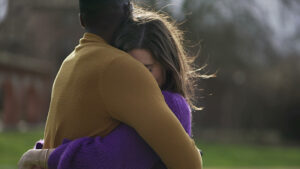 Two people hug after one of them makes amends in recovery.