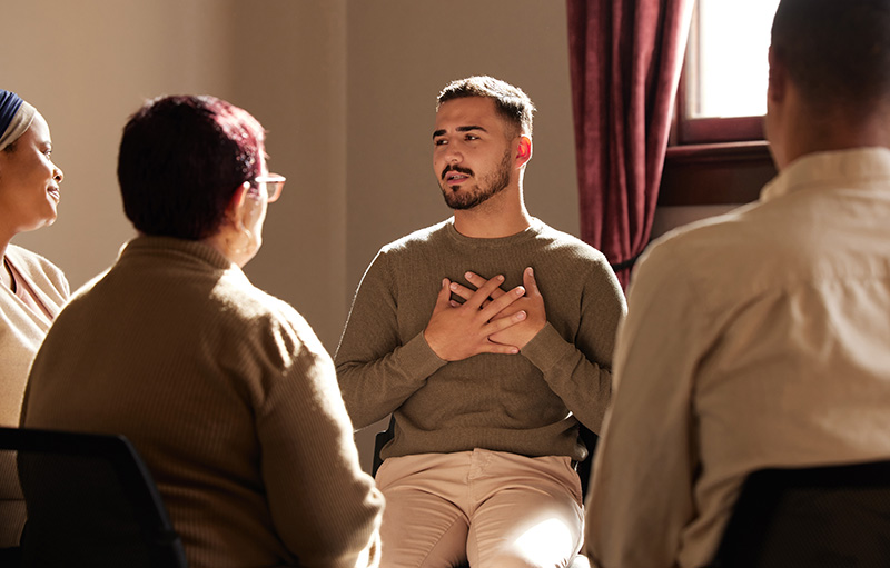 A person participates in group therapy as part of a dual diagnosis treatment program.