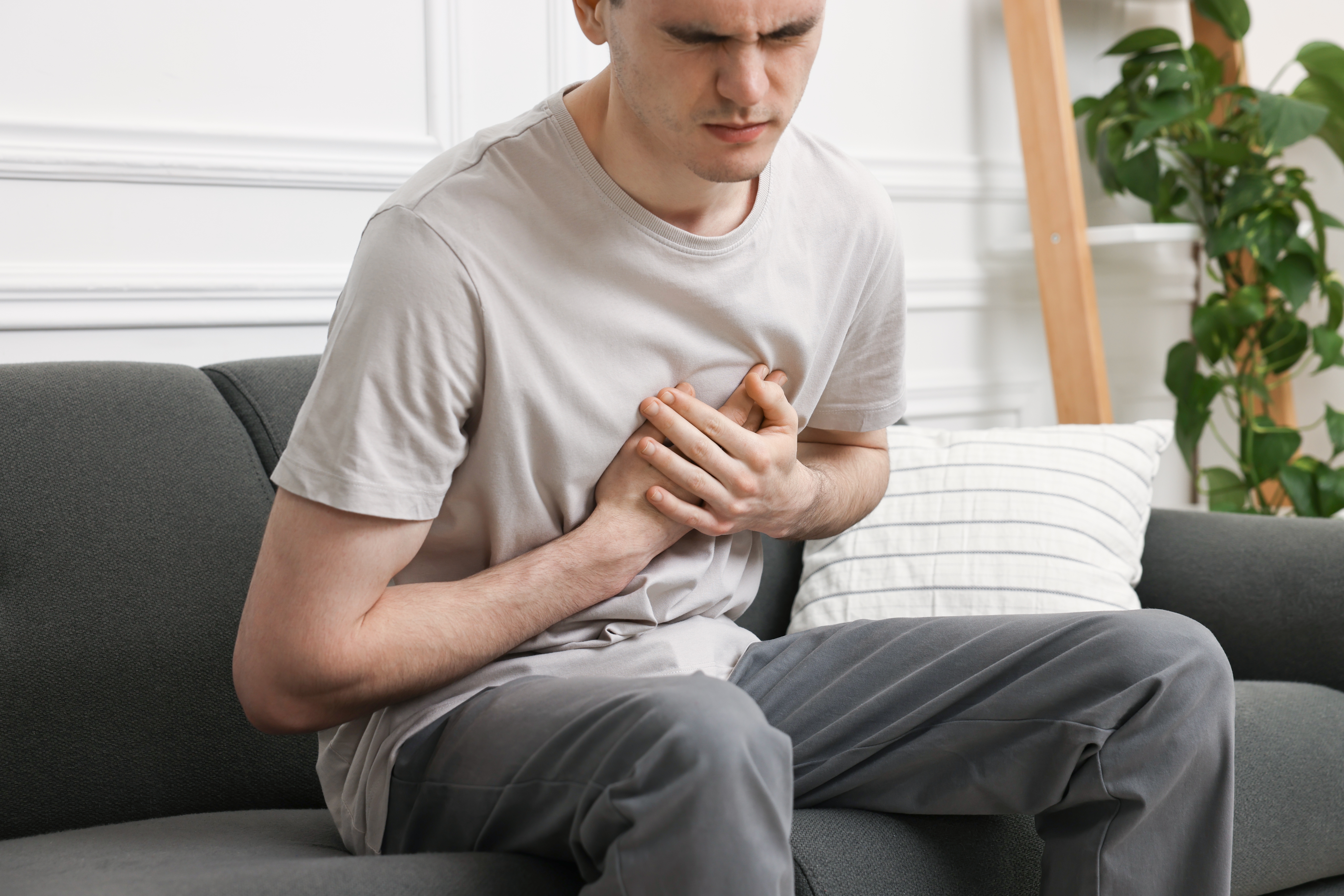 Young man suffering with chest pain after asking does ptsd cause gerd.